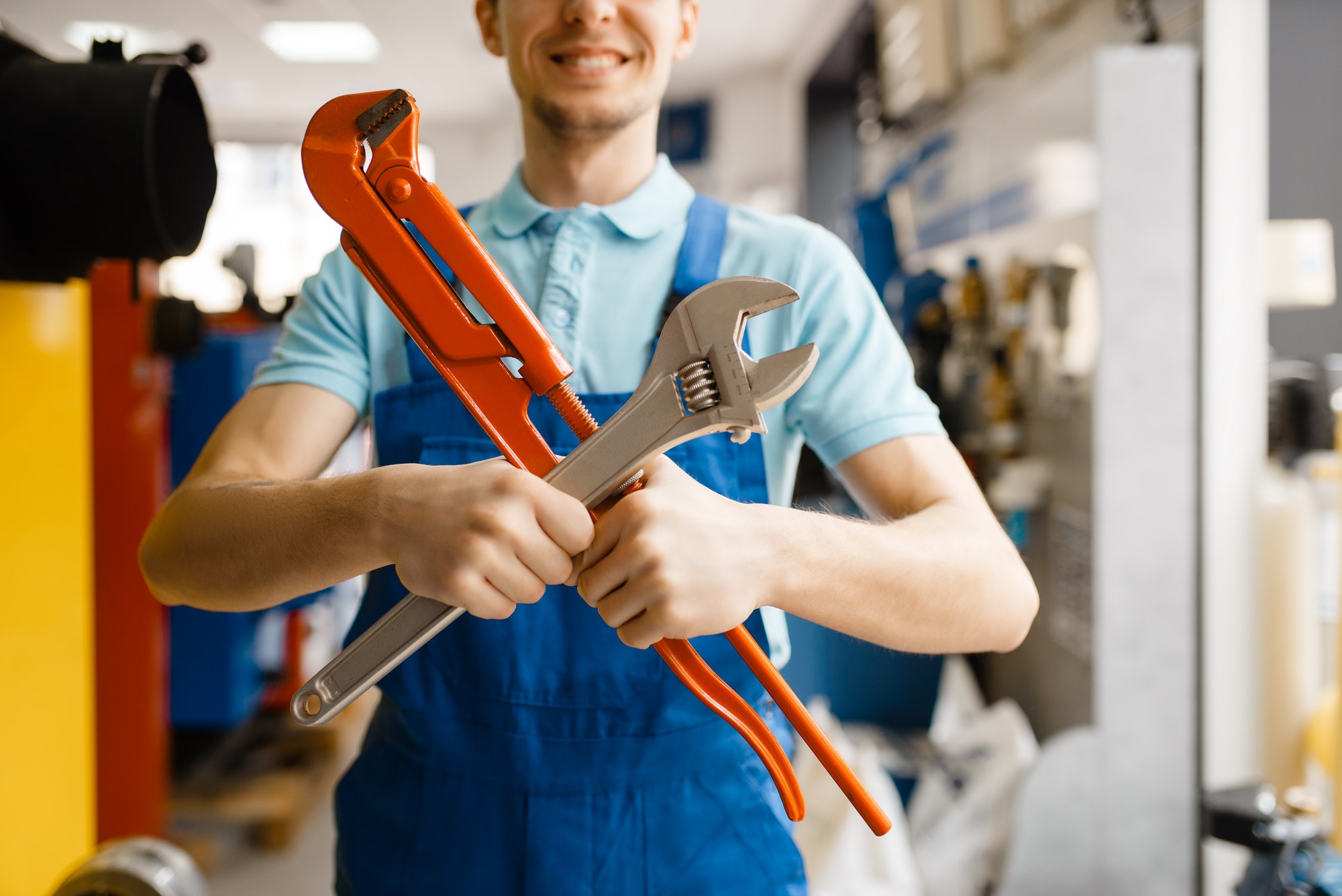 plumber-poses-with-pipe-wrenches-plumbering-store.jpg