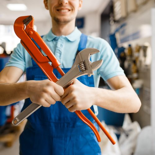 plumber-poses-with-pipe-wrenches-plumbering-store.jpg